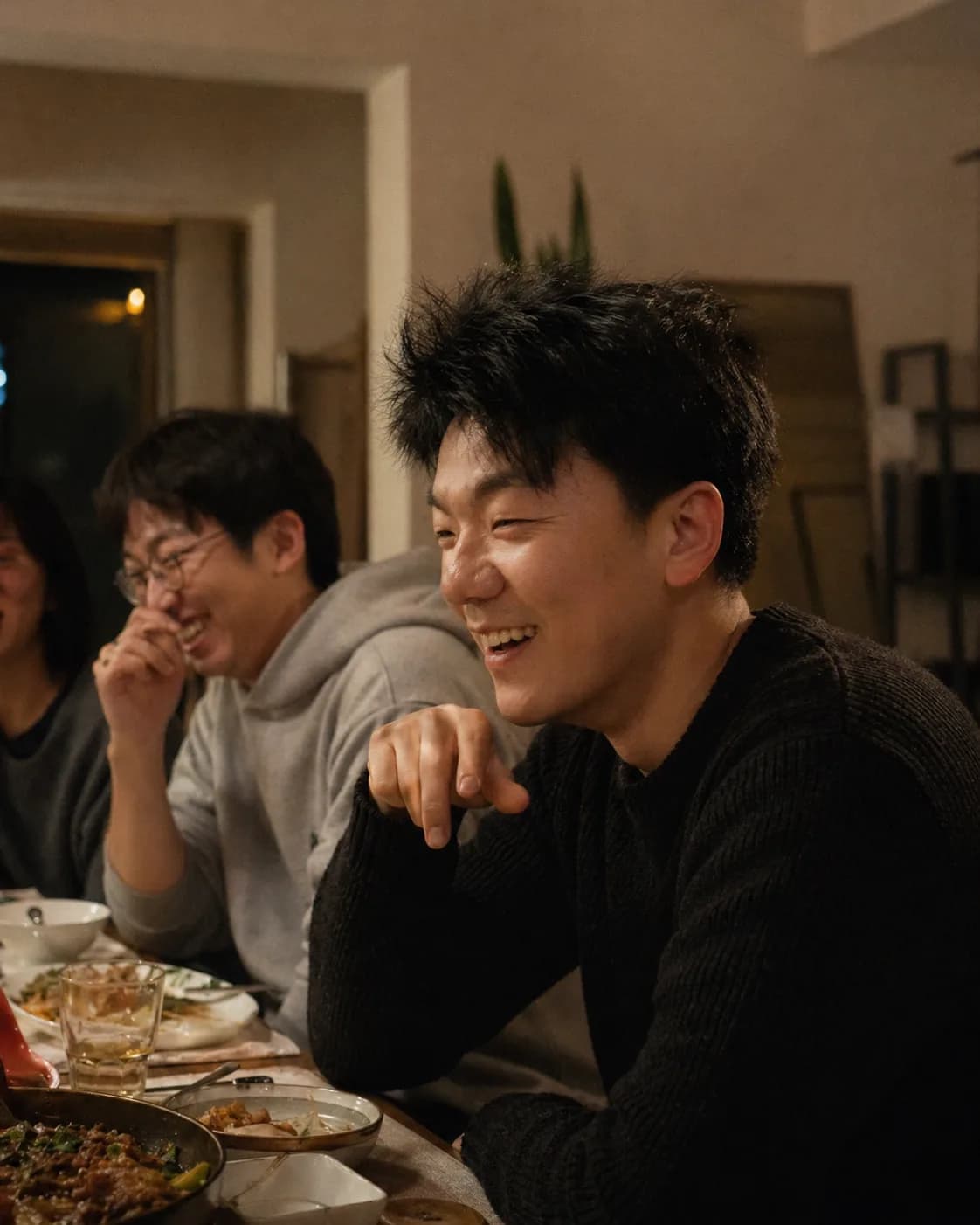Caleb Merridan laughing with friends at dinner