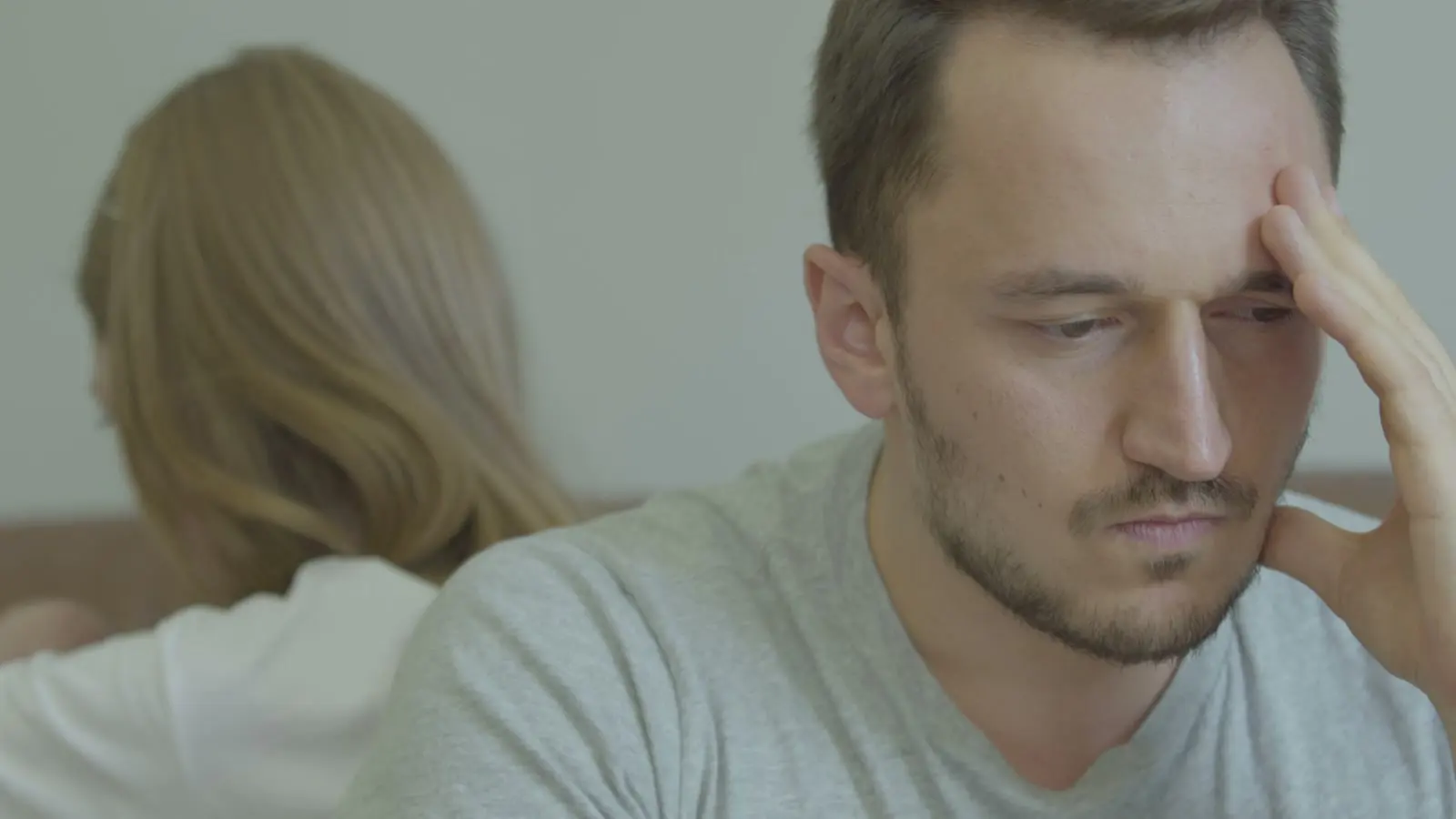 A couple sitting apart during a tense relationship conflict.