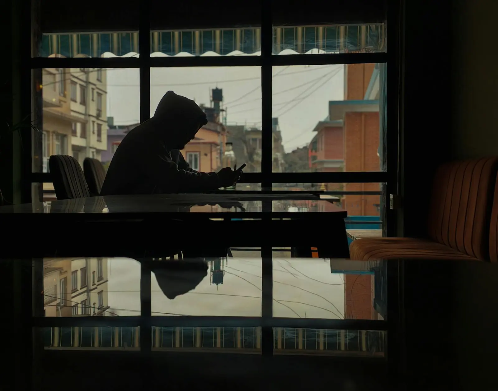 A person alone at a cafe using a phone before sending a difficult message