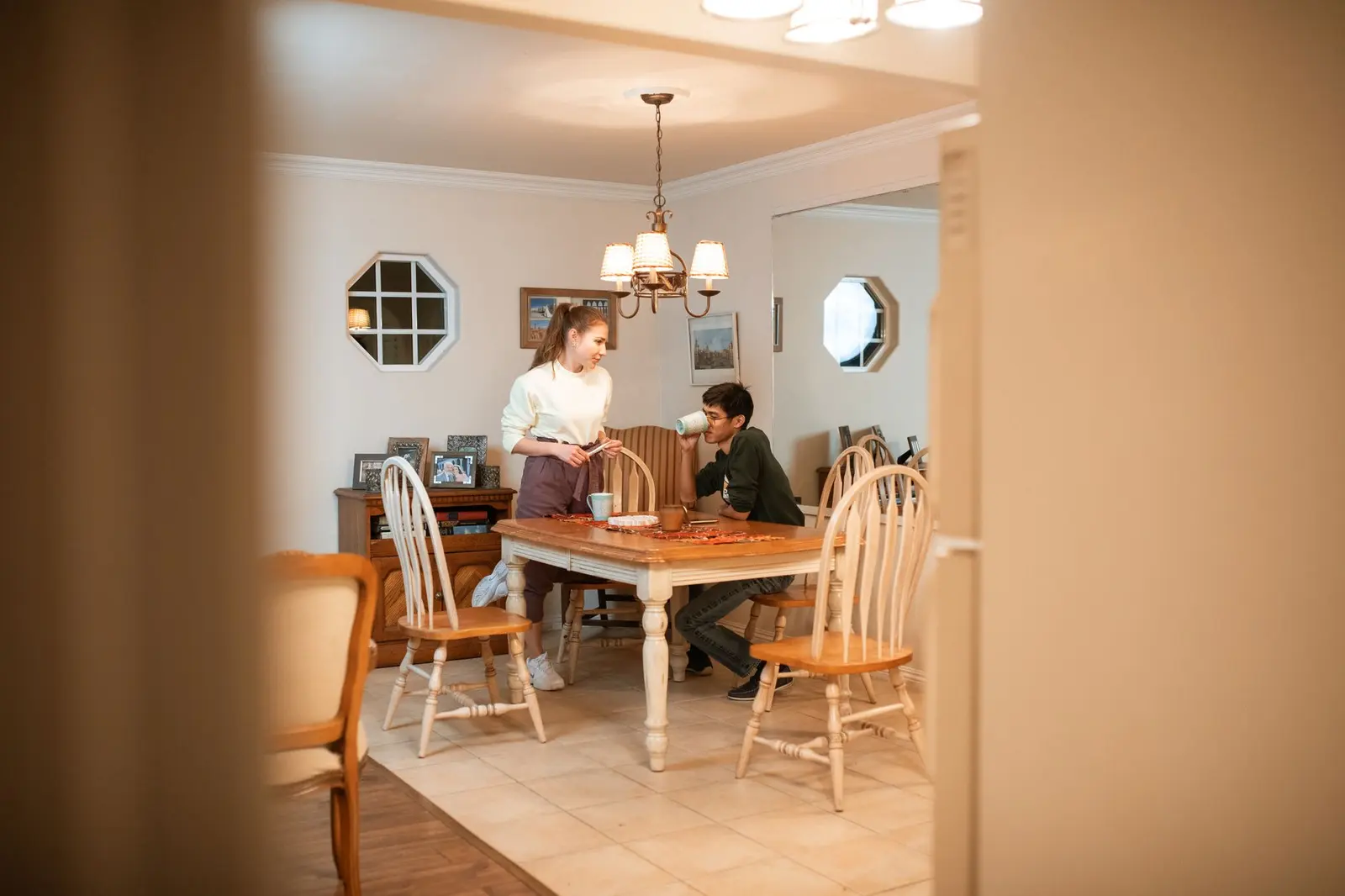 A couple talking casually at a dining table with space between them