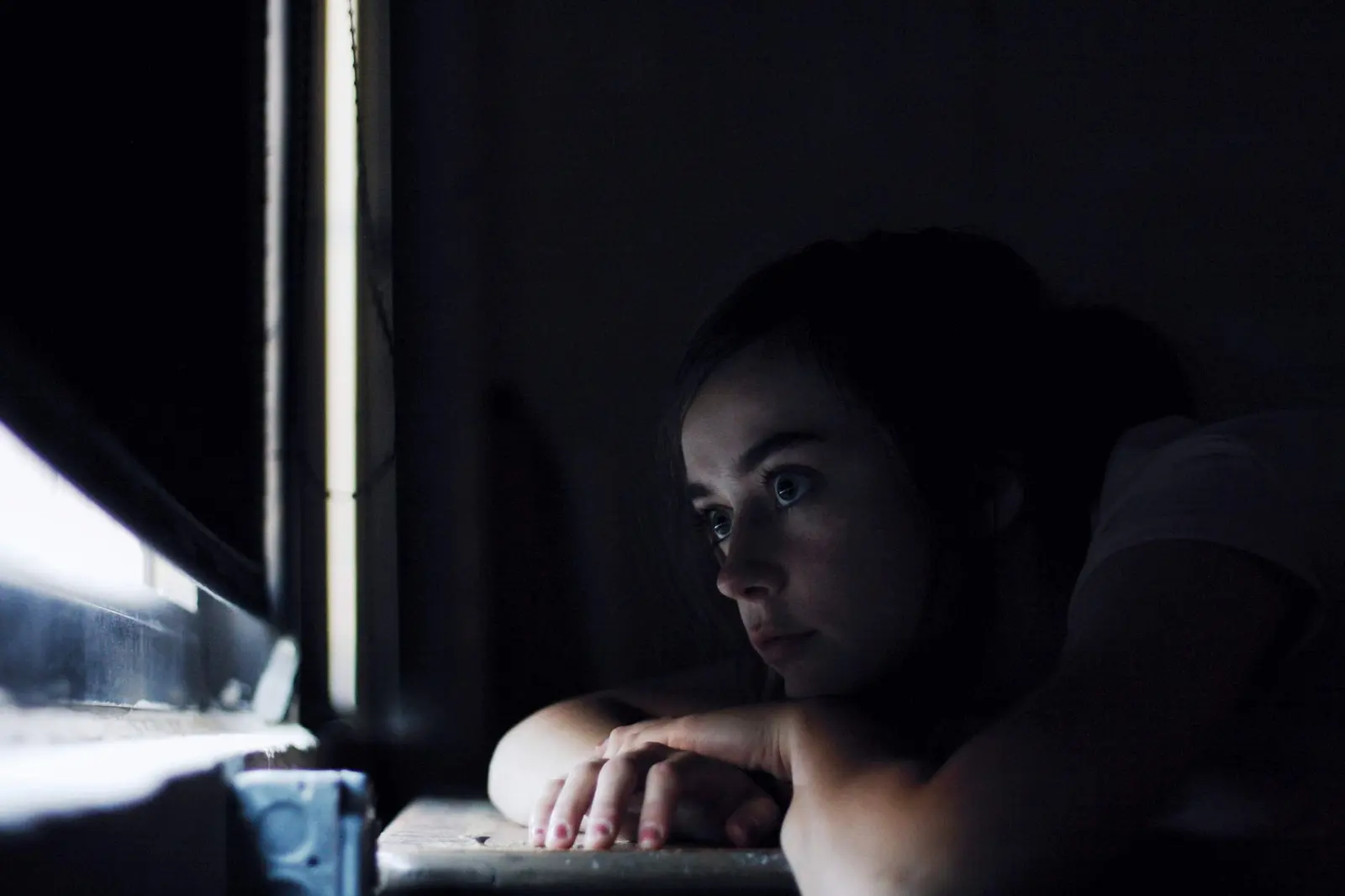 Love Hurts Quotes for Heartbreak, Healing, and Choosing Yourself: a quiet person sitting near a window after heartbreak