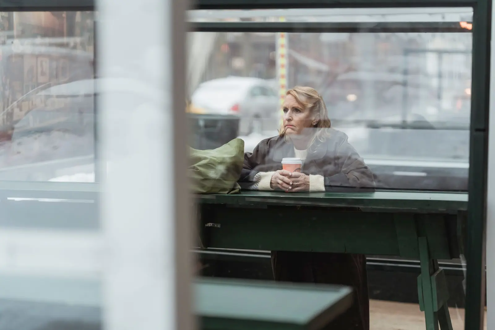 Love Hurts Quotes for Heartbreak, Healing, and Choosing Yourself: one person sitting alone by a cafe window