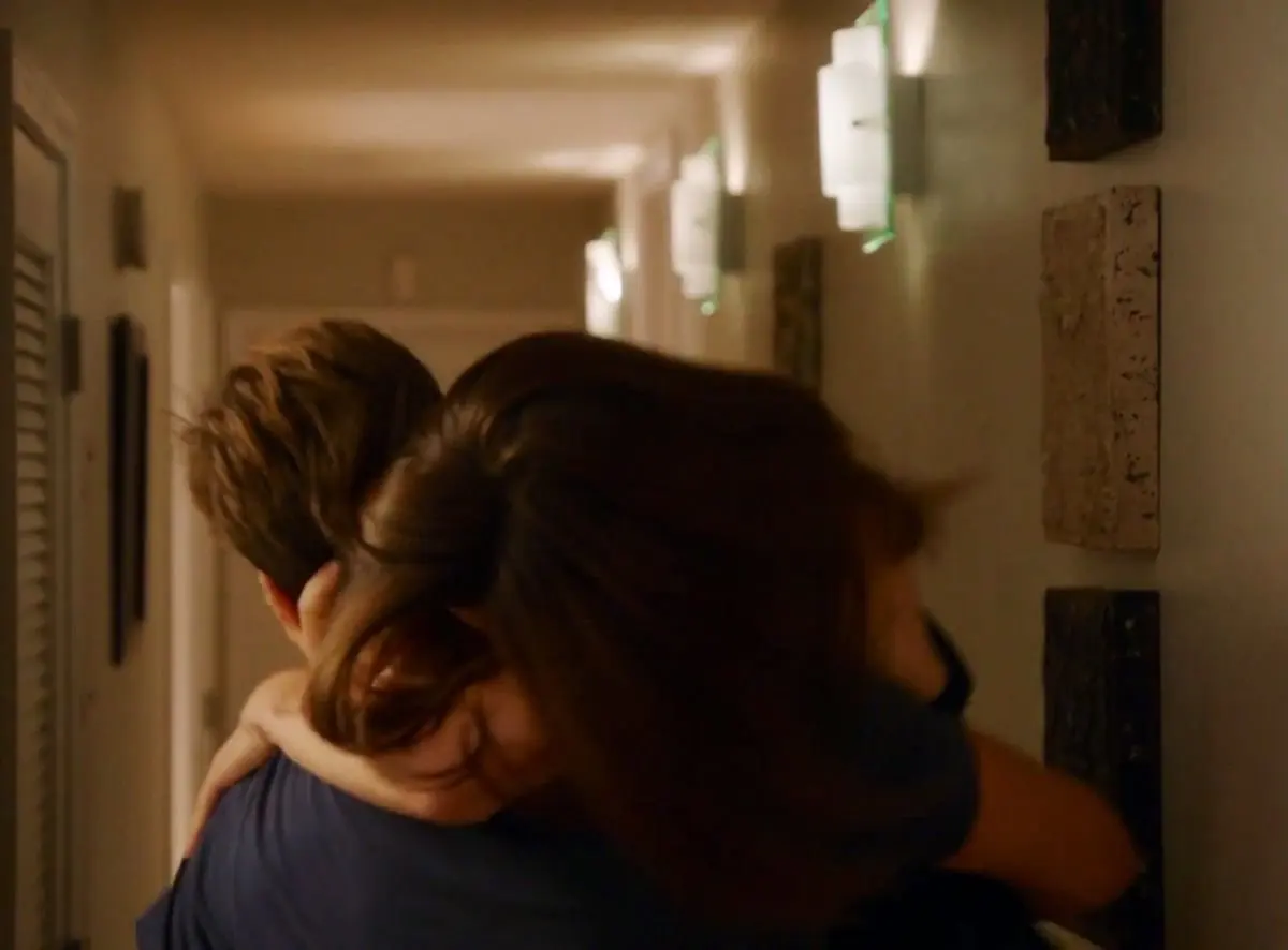 May-December relationship: a partner carrying the other through a softly lit hallway