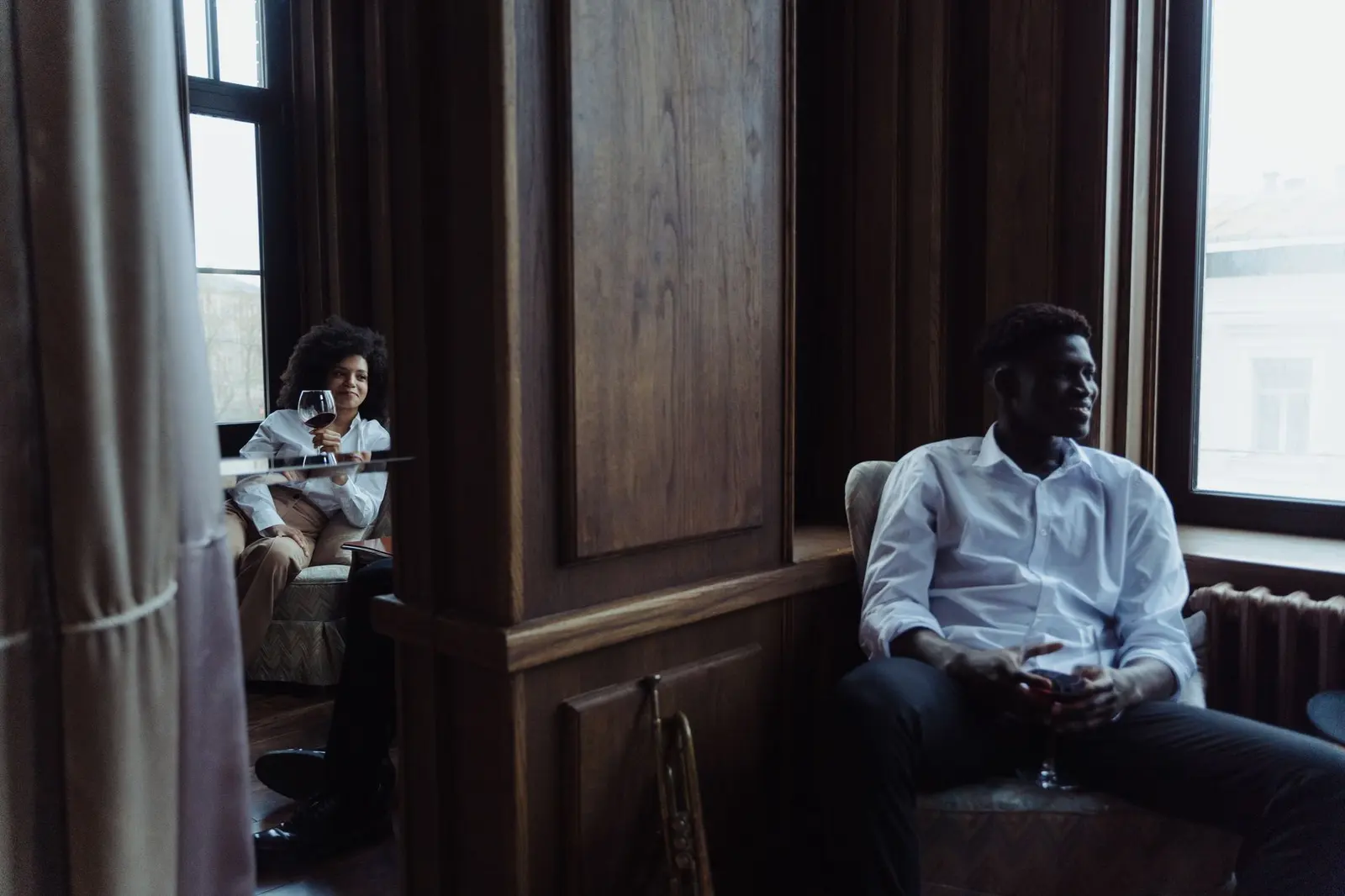 Two people sitting apart in a quiet room, suggesting emotional distance inside a relationship.