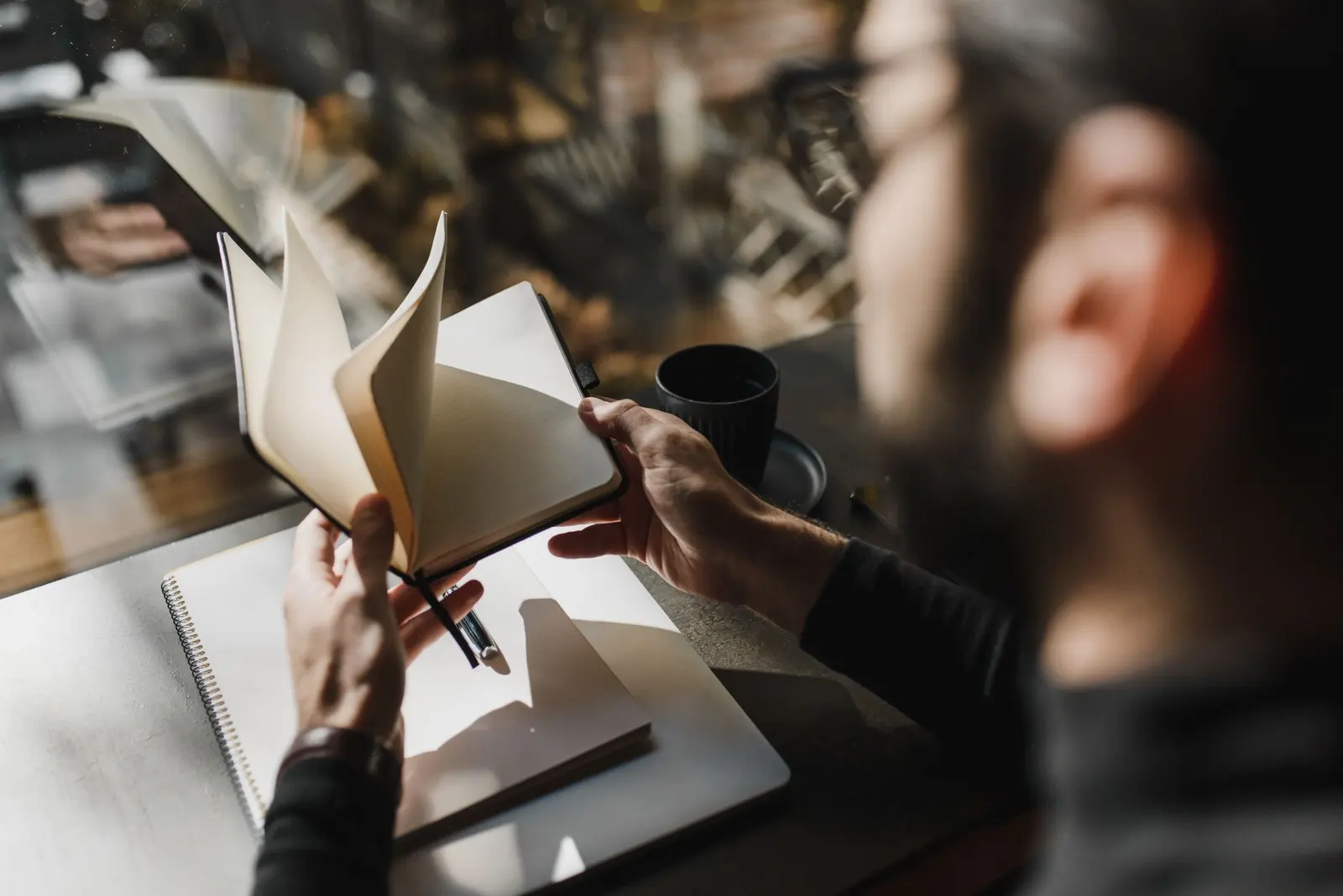 A person turning blank notebook pages during a private relationship reflection