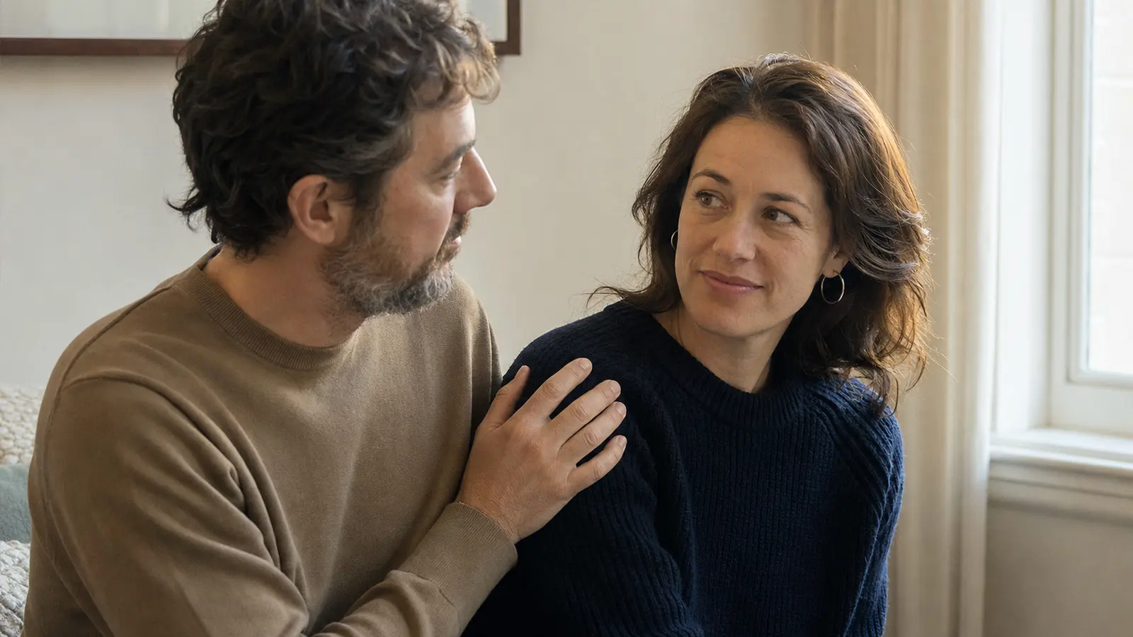 A partner offers a reassuring hand on the shoulder and warm eye contact