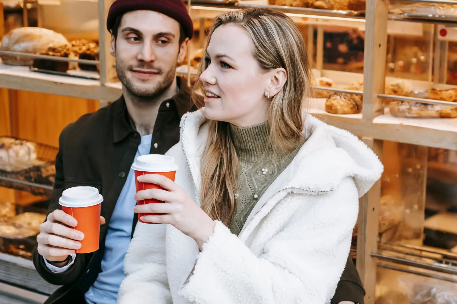 A smiling couple talking over coffee as early dating starts to feel mutual