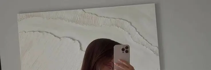 A quiet mirror view of someone holding a phone with the screen hidden before replying.