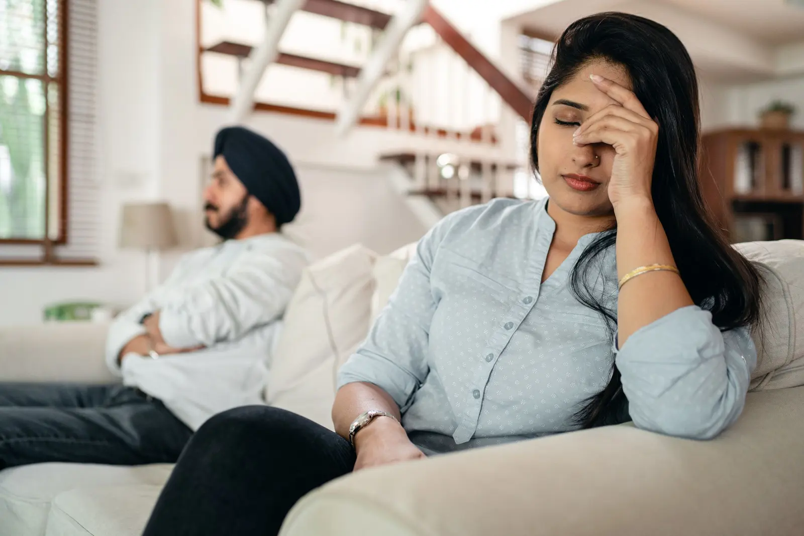Why Is My Boyfriend So Mean to Me? Signs and What to Do: an upset couple sitting apart after conflict